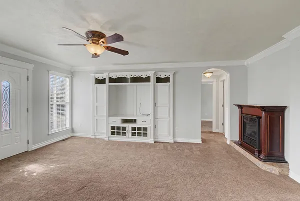 an empty room with windows cabinet and fireplace