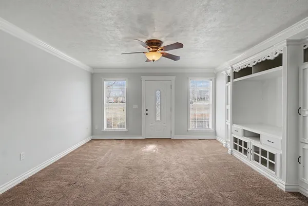 a view of an empty room with a cabinet and a window