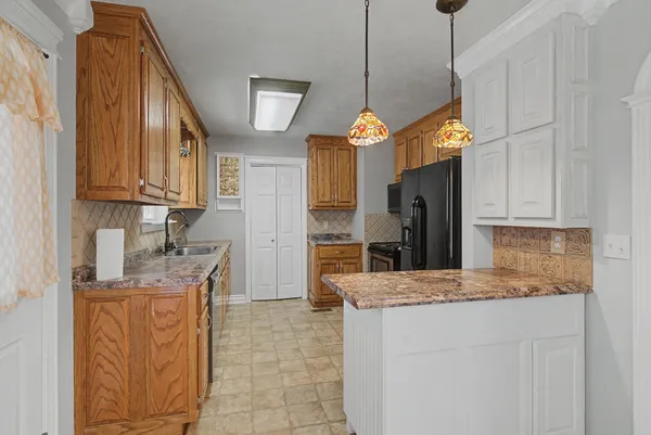 a kitchen with stainless steel appliances granite countertop a sink a stove refrigerator and cabinets