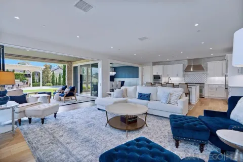 a living room with furniture and a view of kitchen