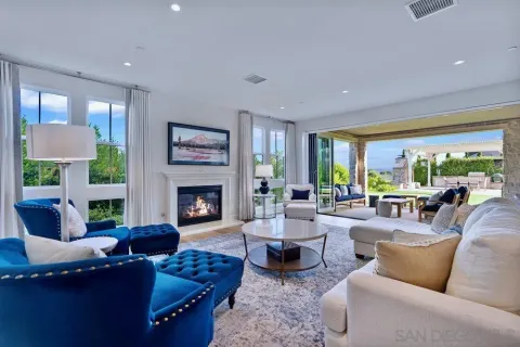 a living room with furniture fireplace and a large window