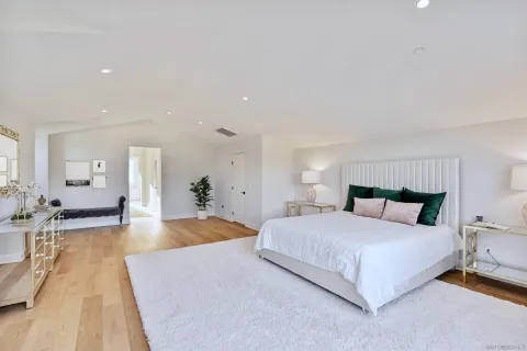 a bedroom with a bed and a view of living room
