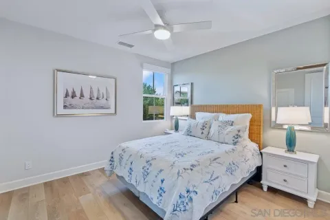 a bedroom with a large bed and a lamp on dresser