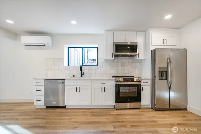 a kitchen with stainless steel appliances a stove a sink and a microwave