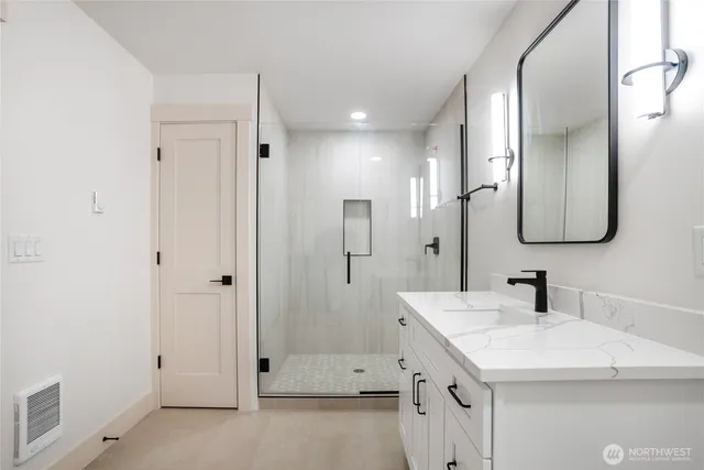 a bathroom with a double vanity sink mirror and shower
