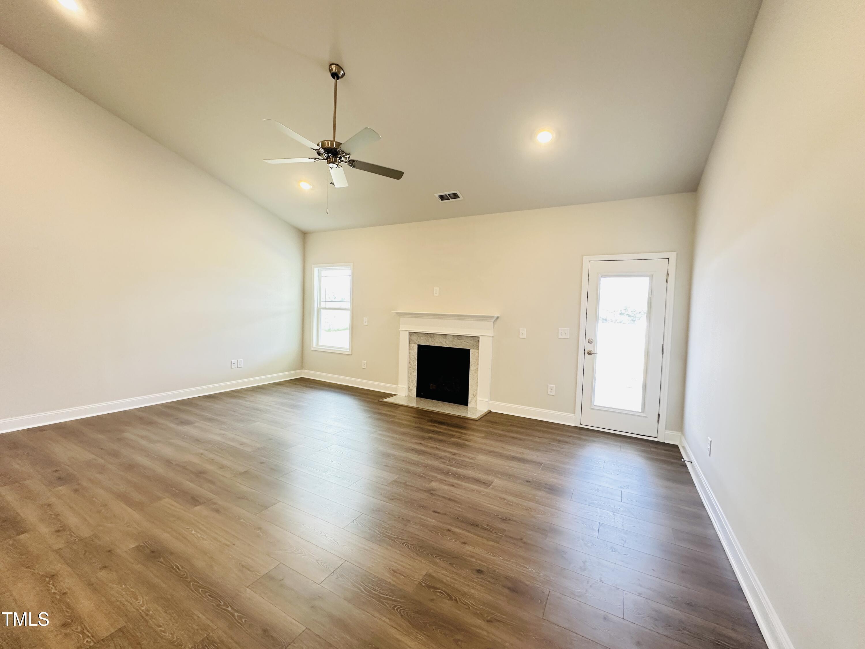 4020 Fletcher Road Bailey, NC 27807 - Photo 6 of 30 an empty room with wooden floor ceiling fan and windows