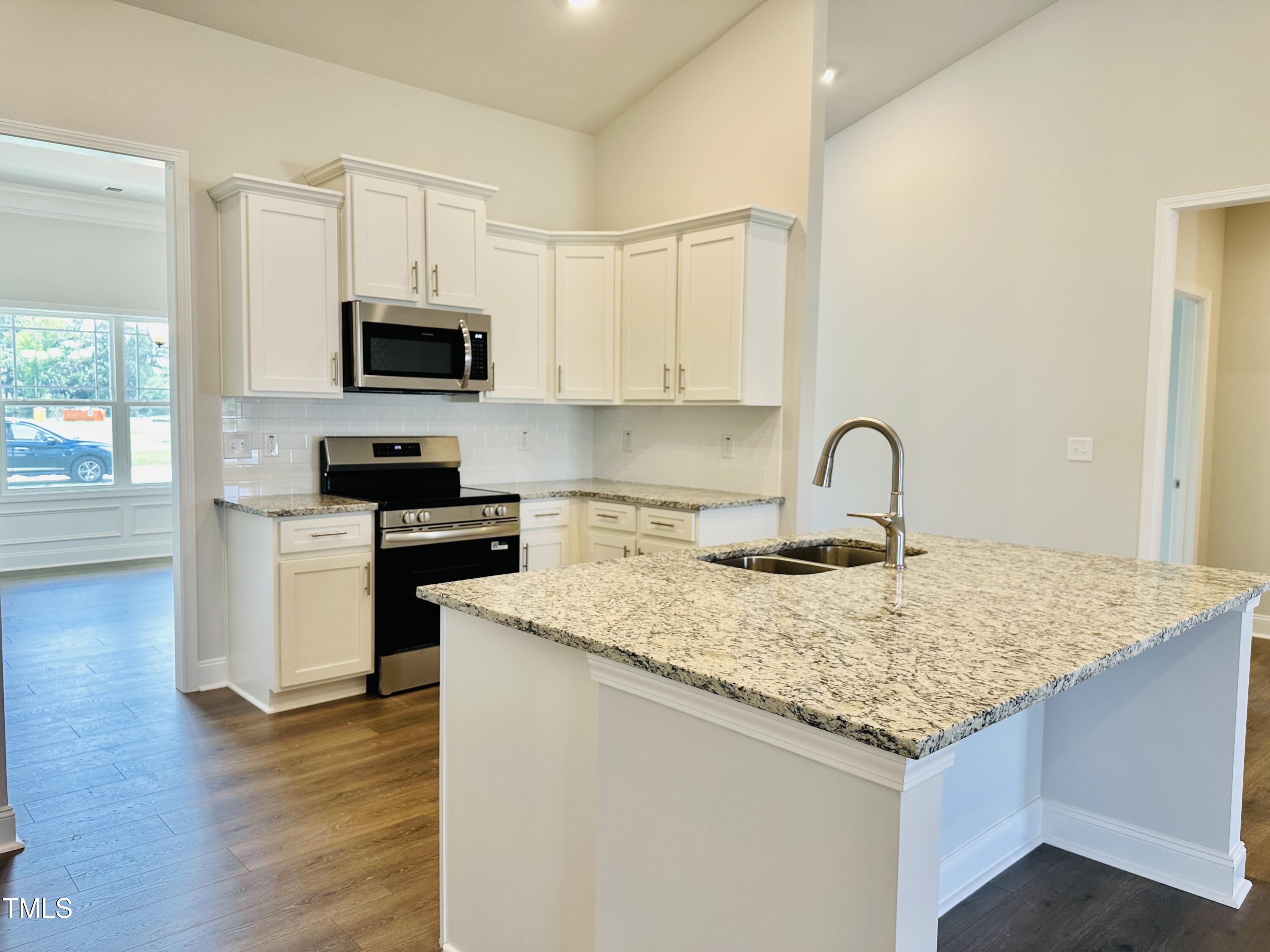 4020 Fletcher Road Bailey, NC 27807 - Photo 9 of 30 a kitchen with granite countertop a sink dishwasher stove and microwave with wooden floor