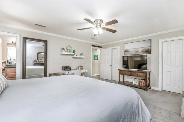 a bedroom with a bed and a large mirror