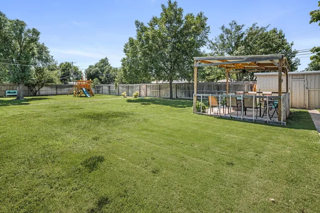 a view of a house with backyard and sitting area