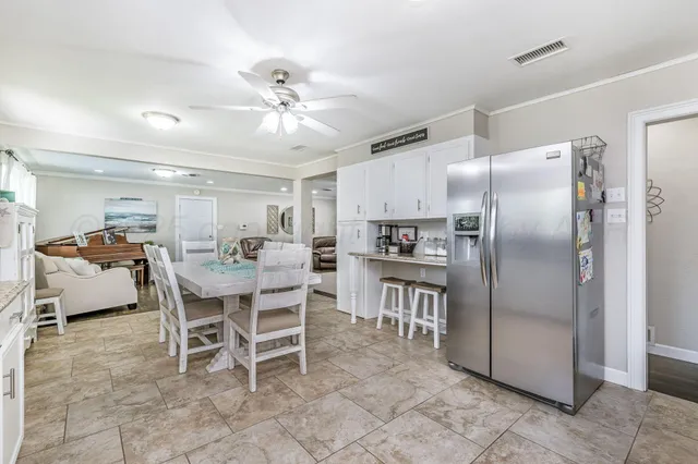a kitchen with stainless steel appliances a table chairs and a refrigerator