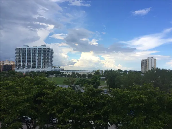 a view of a city with lush green forest