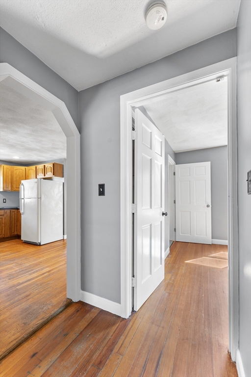 211 Burrill Street Swampscott, MA 01907 - Photo 25 of 39 a view of hallway with an empty room and wooden floor