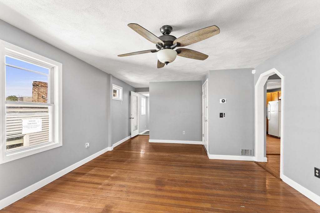 211 Burrill Street Swampscott, MA 01907 - Photo 4 of 39 a view of an empty room with wooden floor and a window