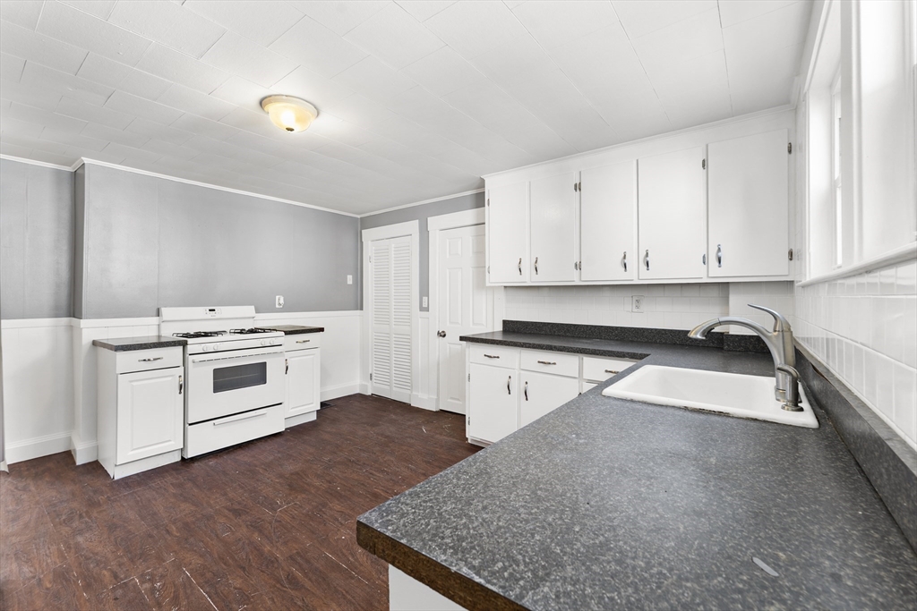 211 Burrill Street Swampscott, MA 01907 - Photo 7 of 39 a kitchen with granite countertop white cabinets and white appliances