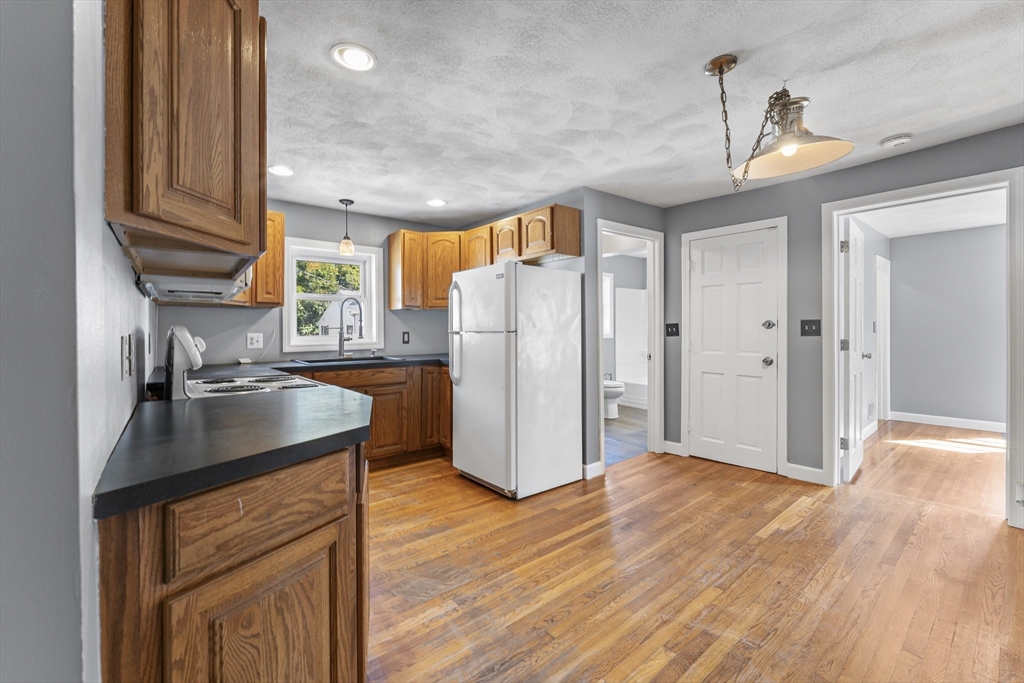211 Burrill Street Swampscott, MA 01907 - Photo 9 of 39 a kitchen with stainless steel appliances granite countertop a refrigerator a sink dishwasher a stove and a refrigerator with wooden floor
