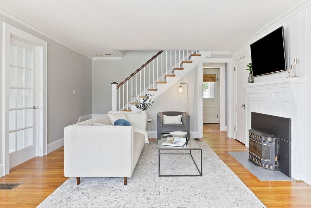 1097 Greendale Avenue Needham, MA 02492 - Photo 6 of 36 a living room with furniture a flat screen tv and a fireplace