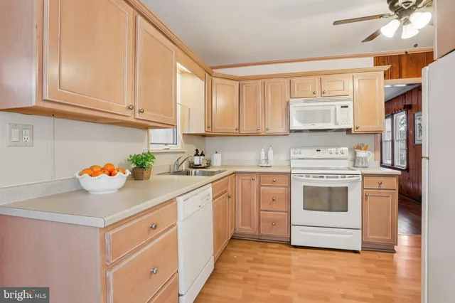 a kitchen with stainless steel appliances white cabinets sink and a window