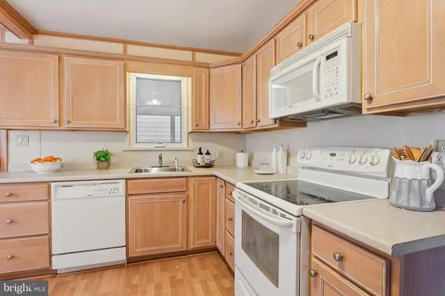 a kitchen with white cabinets and white appliances