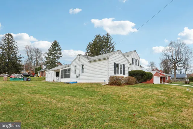 a front view of a house with garden and trees