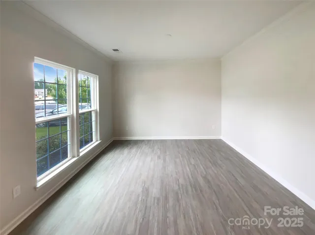 a view of a room with wooden floor and window