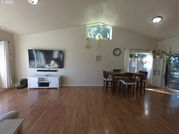 a dining room with furniture a chandelier and wooden floor
