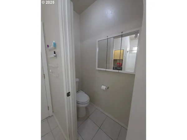 a bathroom with a granite countertop toilet and a sink
