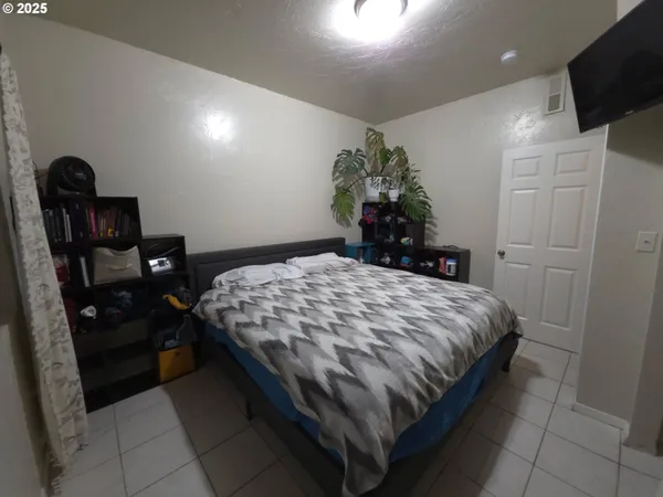 a bedroom with a bed and a potted plant