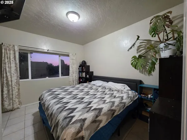 a bedroom with a bed and a painting on the wall