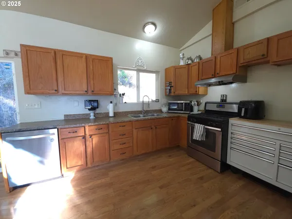 a kitchen with granite countertop a sink stainless steel appliances and cabinets
