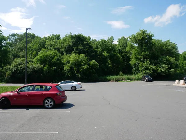 a car parked in front of a house with large trees