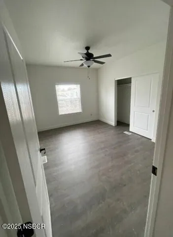 an empty room with windows and fan