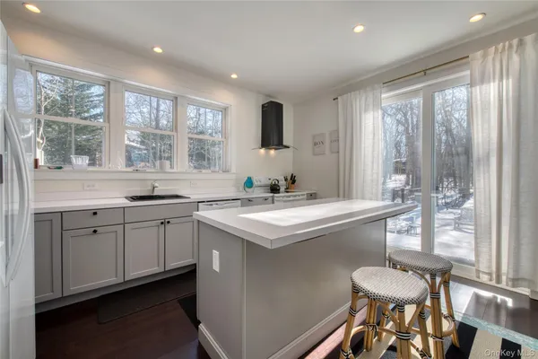 a kitchen with a sink stove and chairs