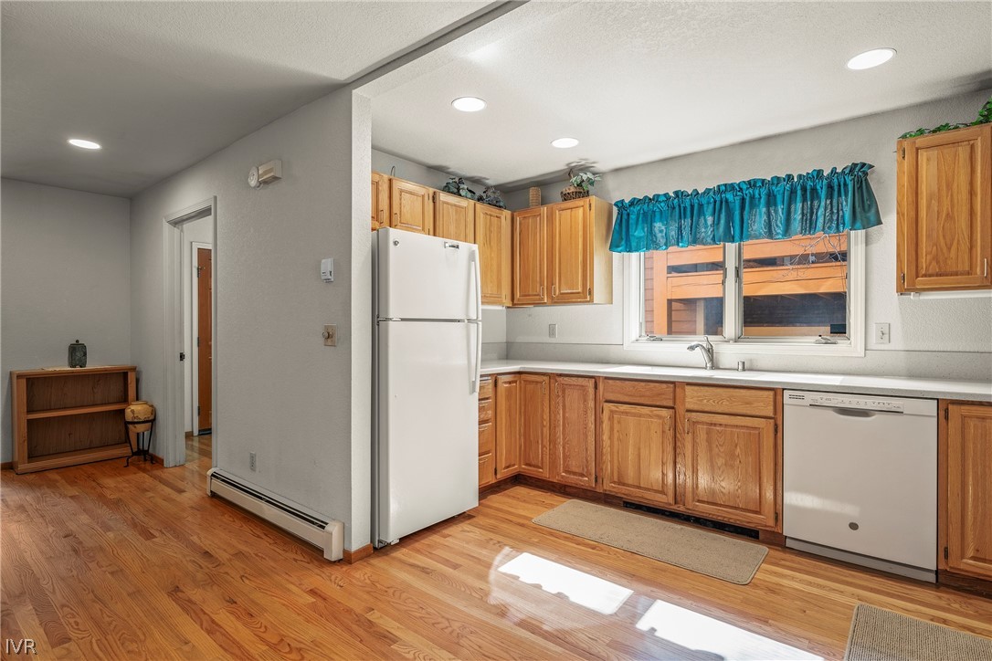 947 Incline Way, Unit 183 Incline Village, NV 89451 - Photo 7 of 37 a kitchen with granite countertop a refrigerator a sink and dishwasher wooden cabinets with wooden floor