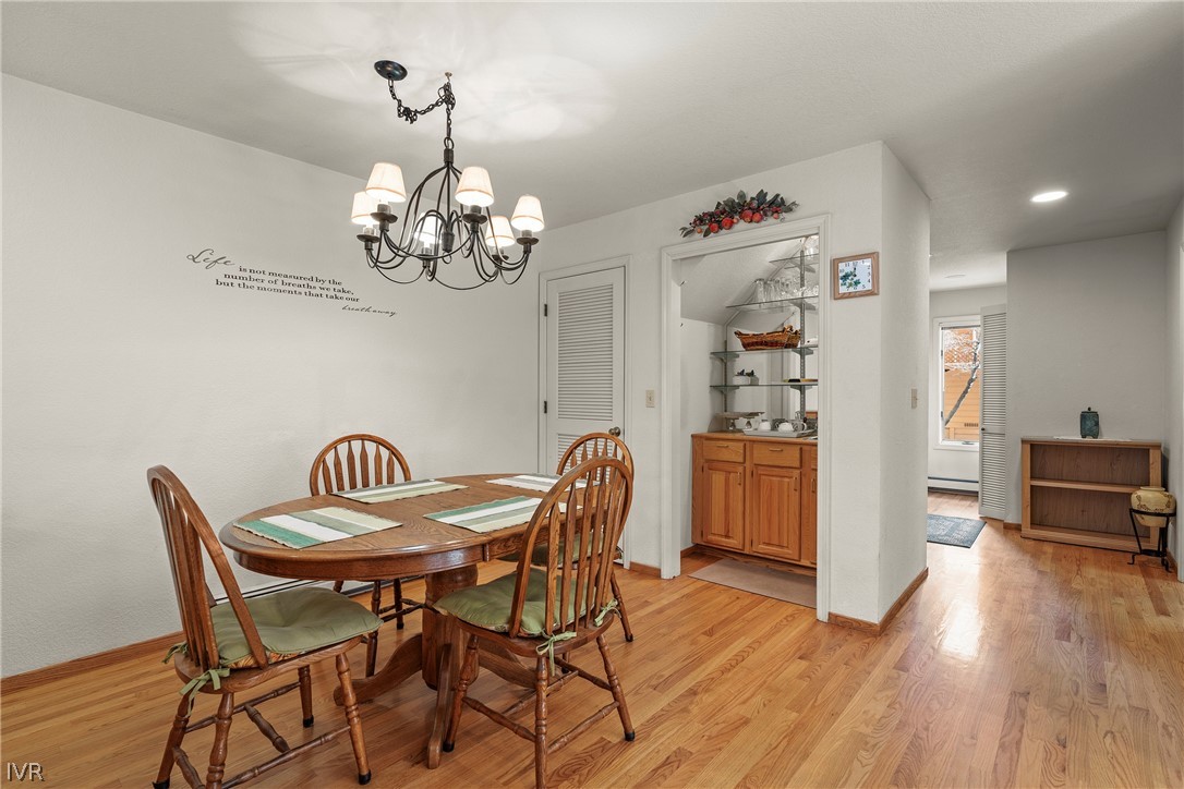 947 Incline Way, Unit 183 Incline Village, NV 89451 - Photo 8 of 37 a dining room with wooden floor a chandelier a wooden table and chairs