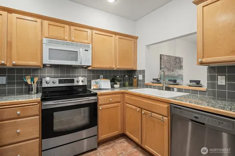 a kitchen with stainless steel appliances granite countertop a sink stove and cabinets