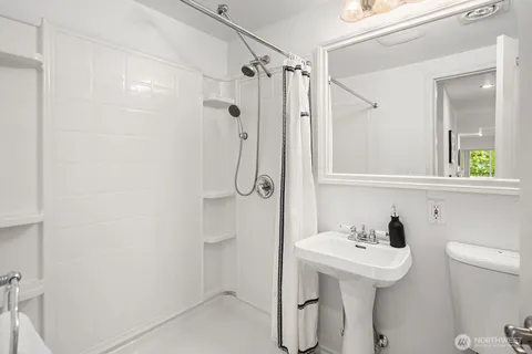 a bathroom with a sink a toilet and shower