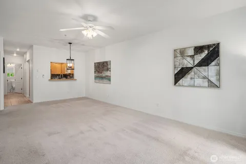 en empty room with windows and ceiling fan