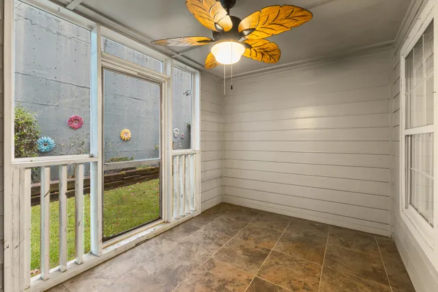 an empty room with a window and a fan