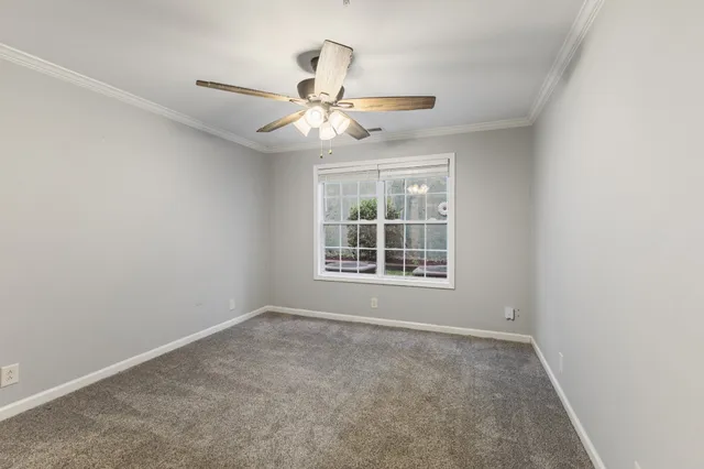 a view of an empty room and chandelier fan