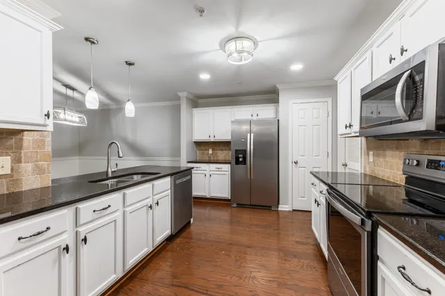 a large white kitchen with lots of counter space and furniture