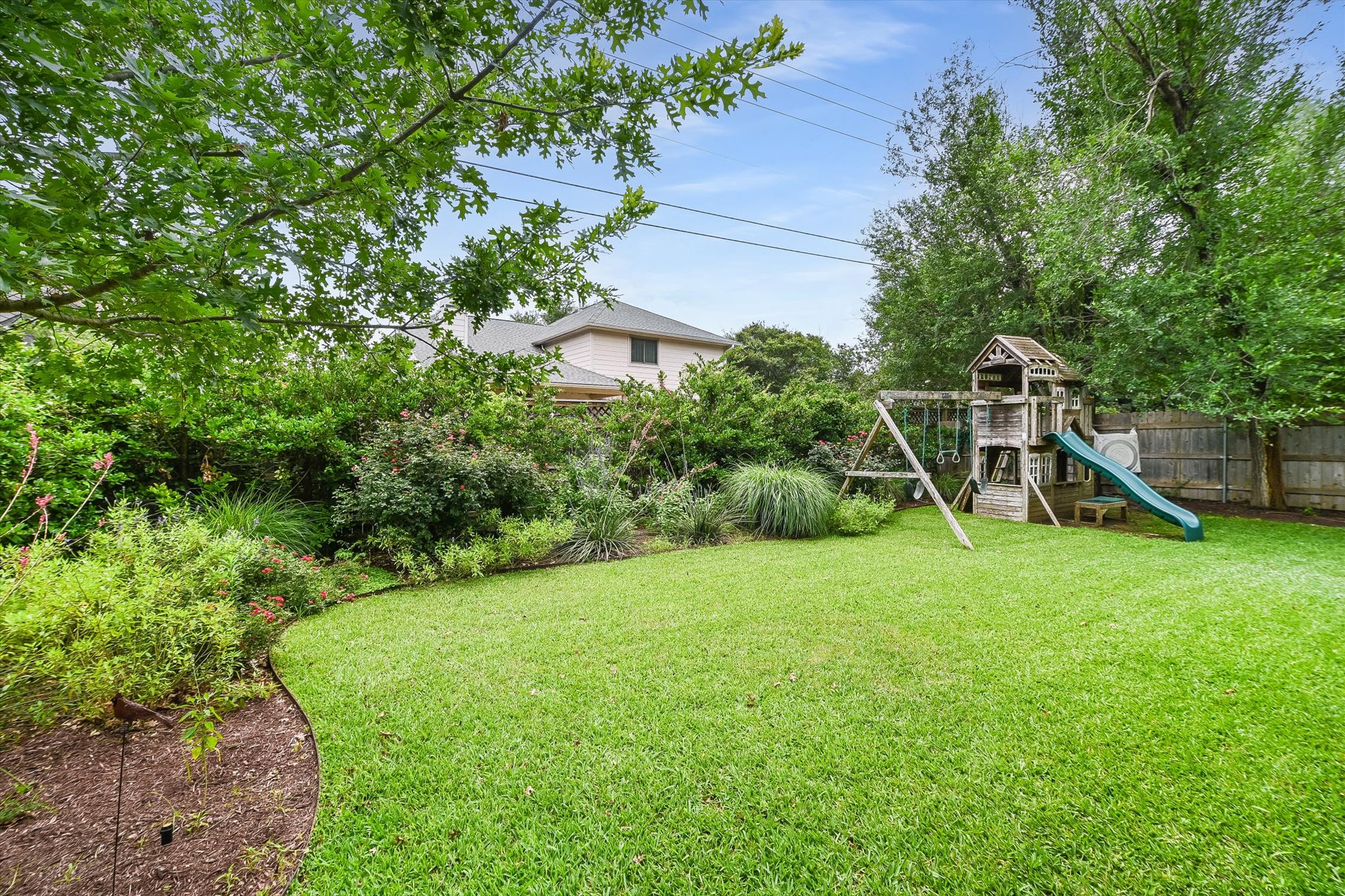 6456 Ruxton Lane Austin, TX 78749 - Photo 28 of 30 A verdant backyard retreat offers ample space for recreation and enjoyment, framed by mature trees and lush plantings.