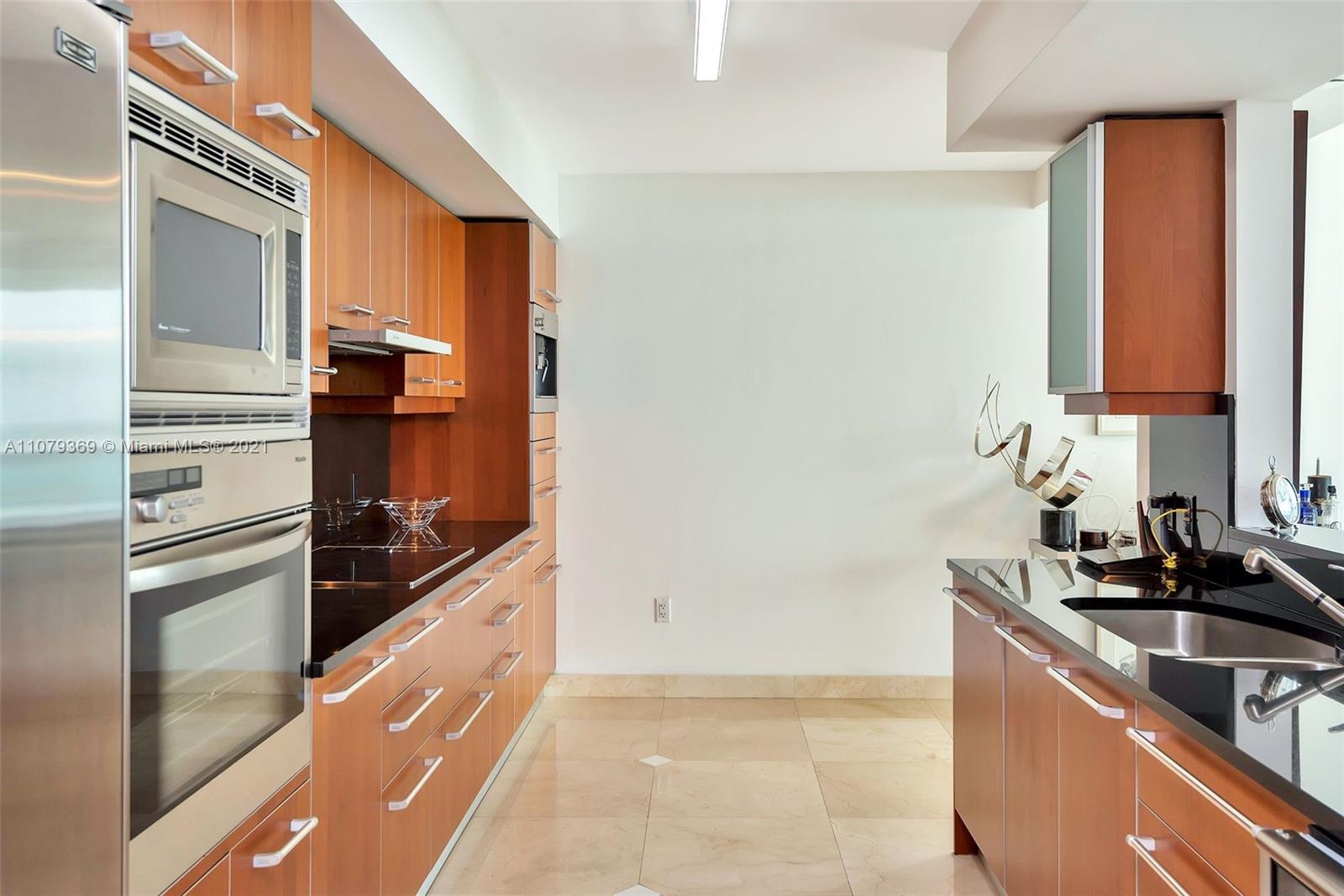 1331 Brickell Bay Drive, Unit 2401 Miami, FL 33131 - Photo 25 of 52 a kitchen with a refrigerator and a sink