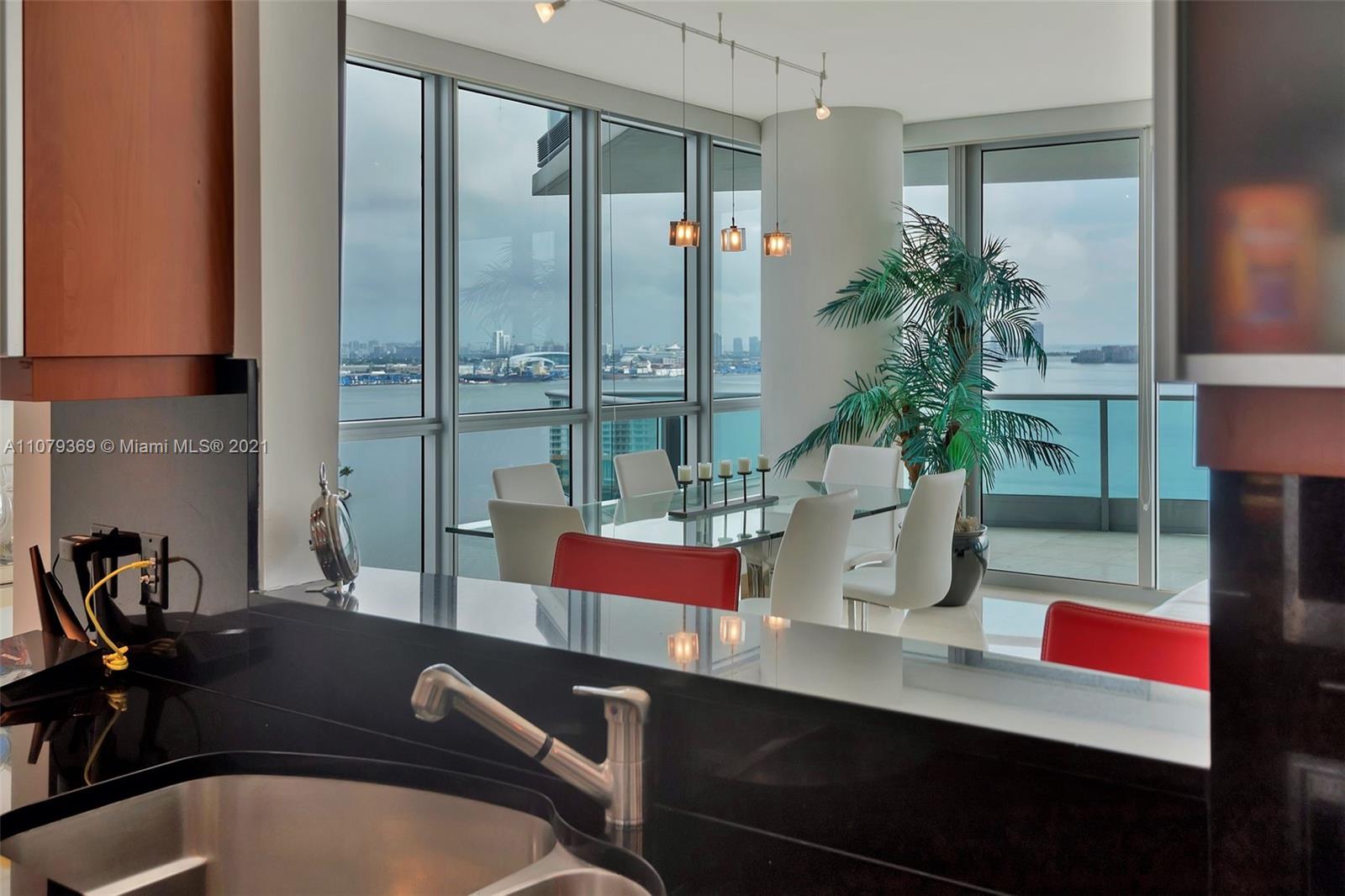 1331 Brickell Bay Drive, Unit 2401 Miami, FL 33131 - Photo 26 of 52 a table with chairs and a potted plant