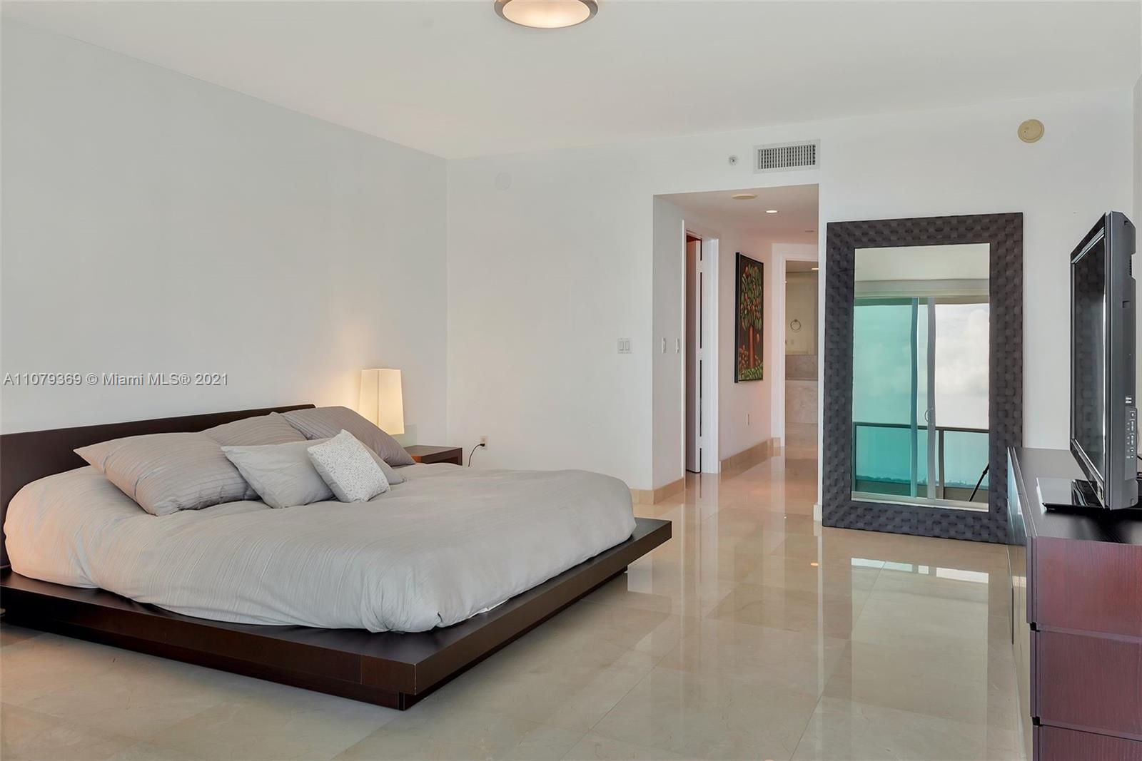1331 Brickell Bay Drive, Unit 2401 Miami, FL 33131 - Photo 39 of 52 a bedroom with a large bed and a tv on table