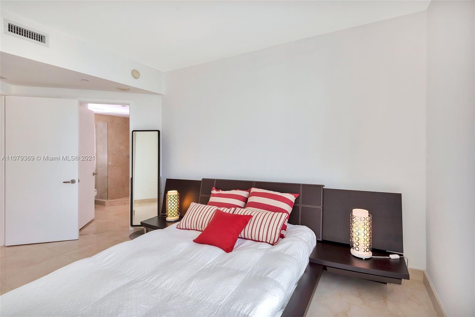 1331 Brickell Bay Drive, Unit 2401 Miami, FL 33131 - Photo 42 of 52 a bedroom with a bed and lamp