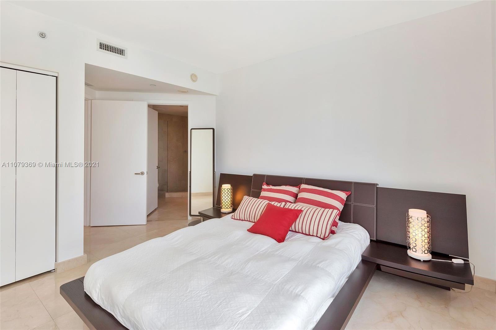 1331 Brickell Bay Drive, Unit 2401 Miami, FL 33131 - Photo 43 of 52 a bedroom with a bed and a mirror