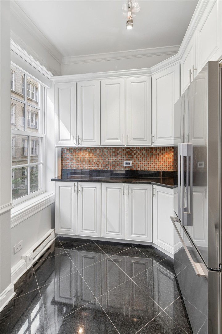 70 East Scott Street, Unit 306 Chicago, IL 60610 - Photo 9 of 17 a view of kitchen with granite countertop white cabinets and refrigerator