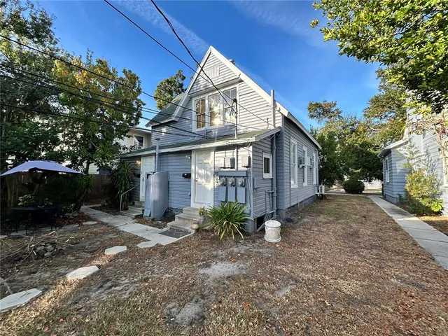 a view of a house with a yard and large tree