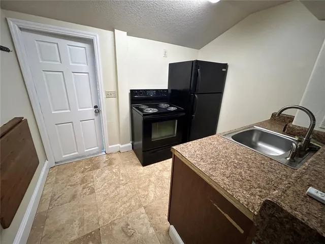 a kitchen with a sink stove and refrigerator