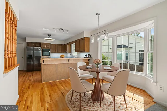 a view of a dining room and livingroom with furniture wooden floor a chandelier